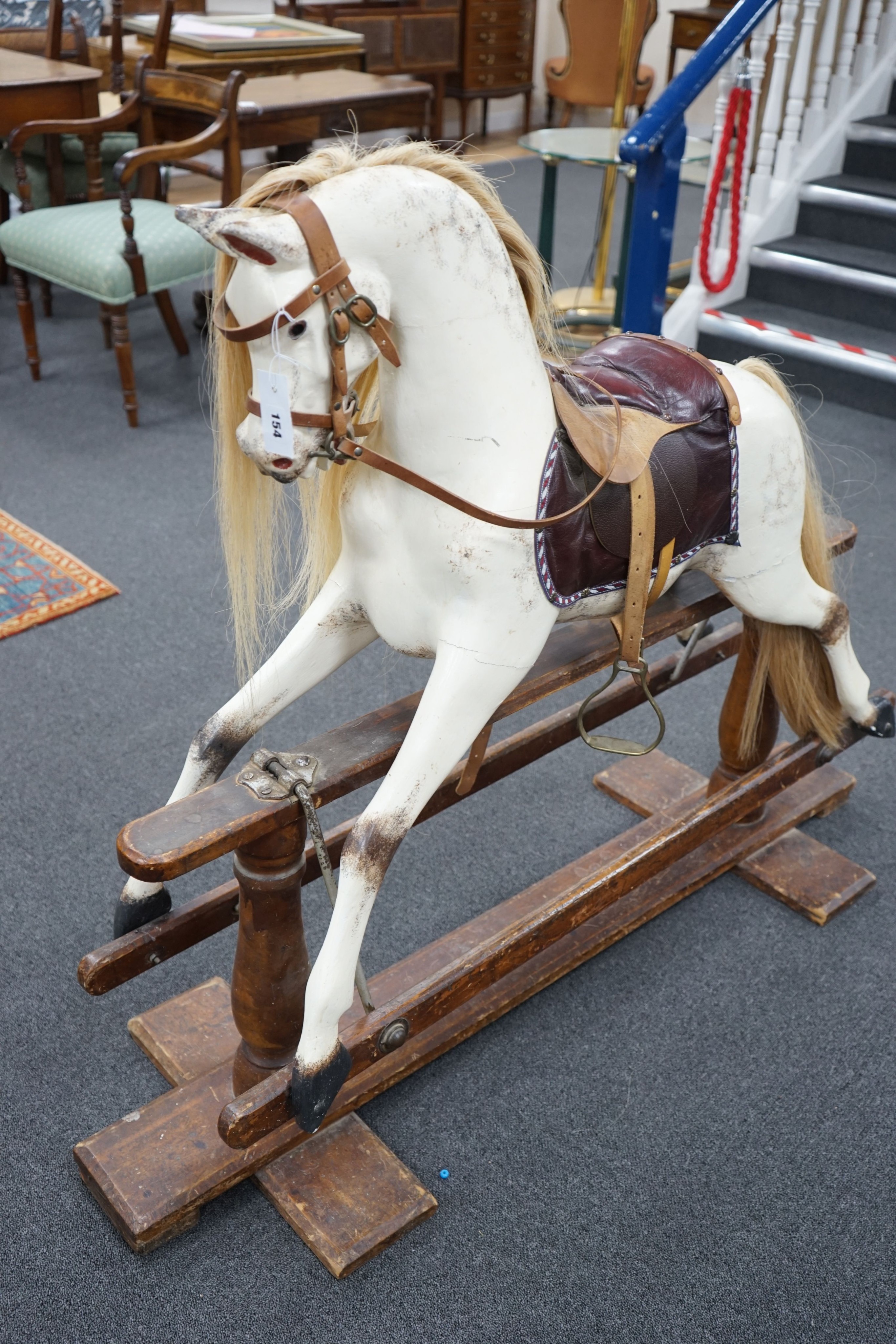 An early 20th century Ayres type dapple grey rocking horse on pine safety frame, width 130cm, height 110cm